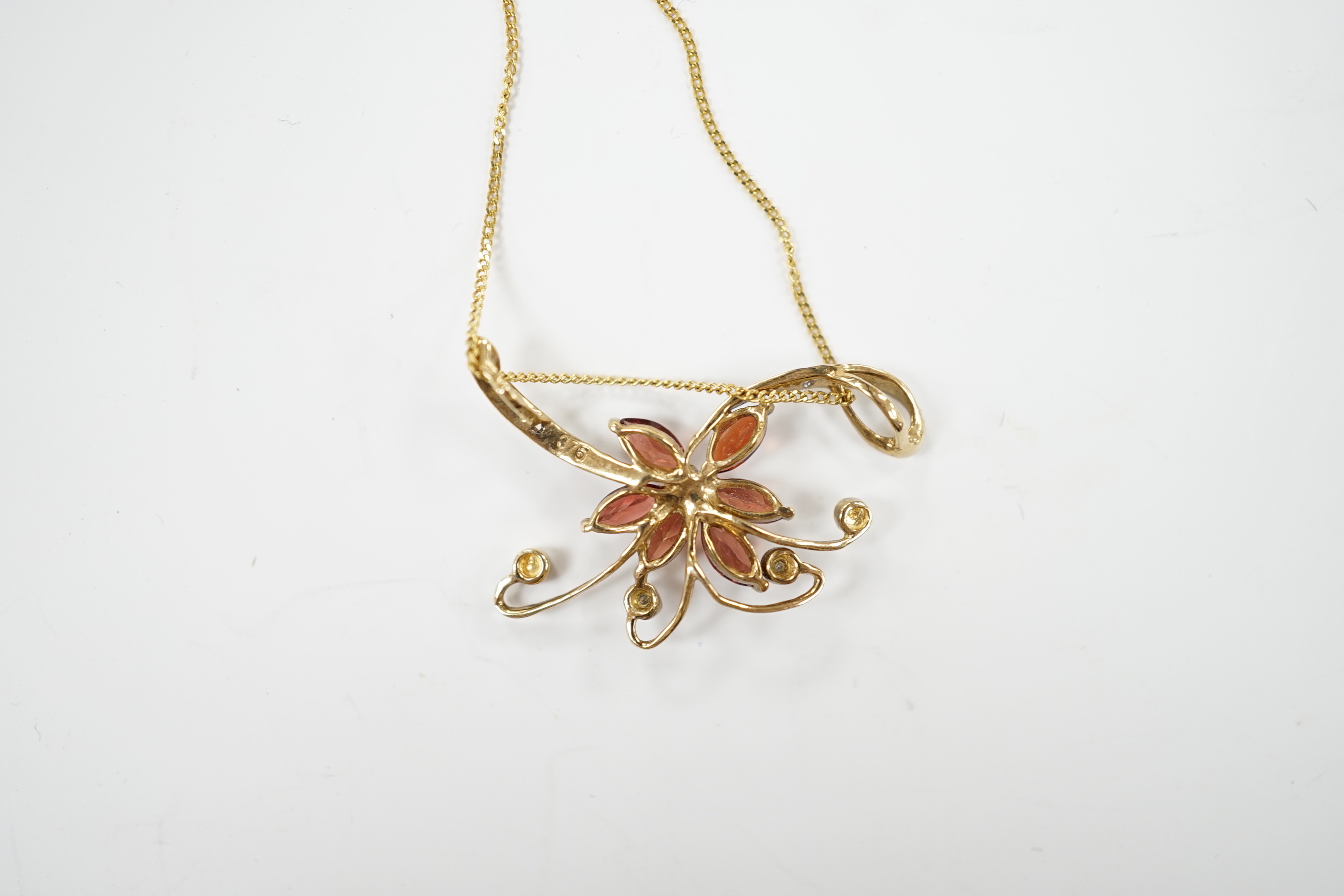 A modern 9ct gold and gem set foliate pendant on chain, pendant 30mm, gross weight 2.6 grams.